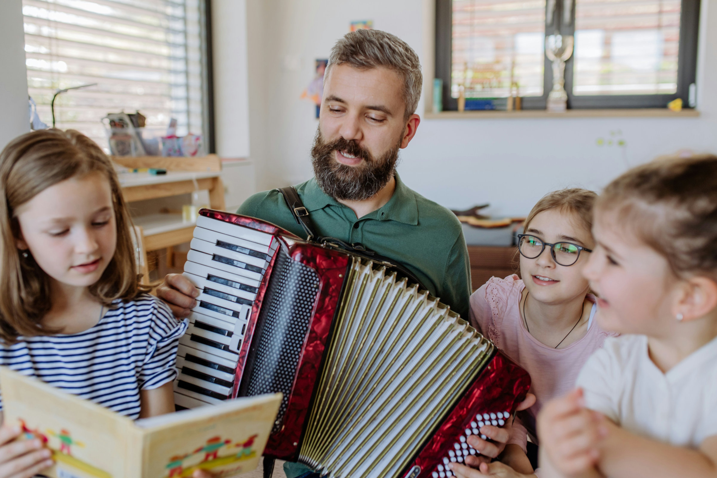 Vater spielt Akkordeon für seine drei Töchter