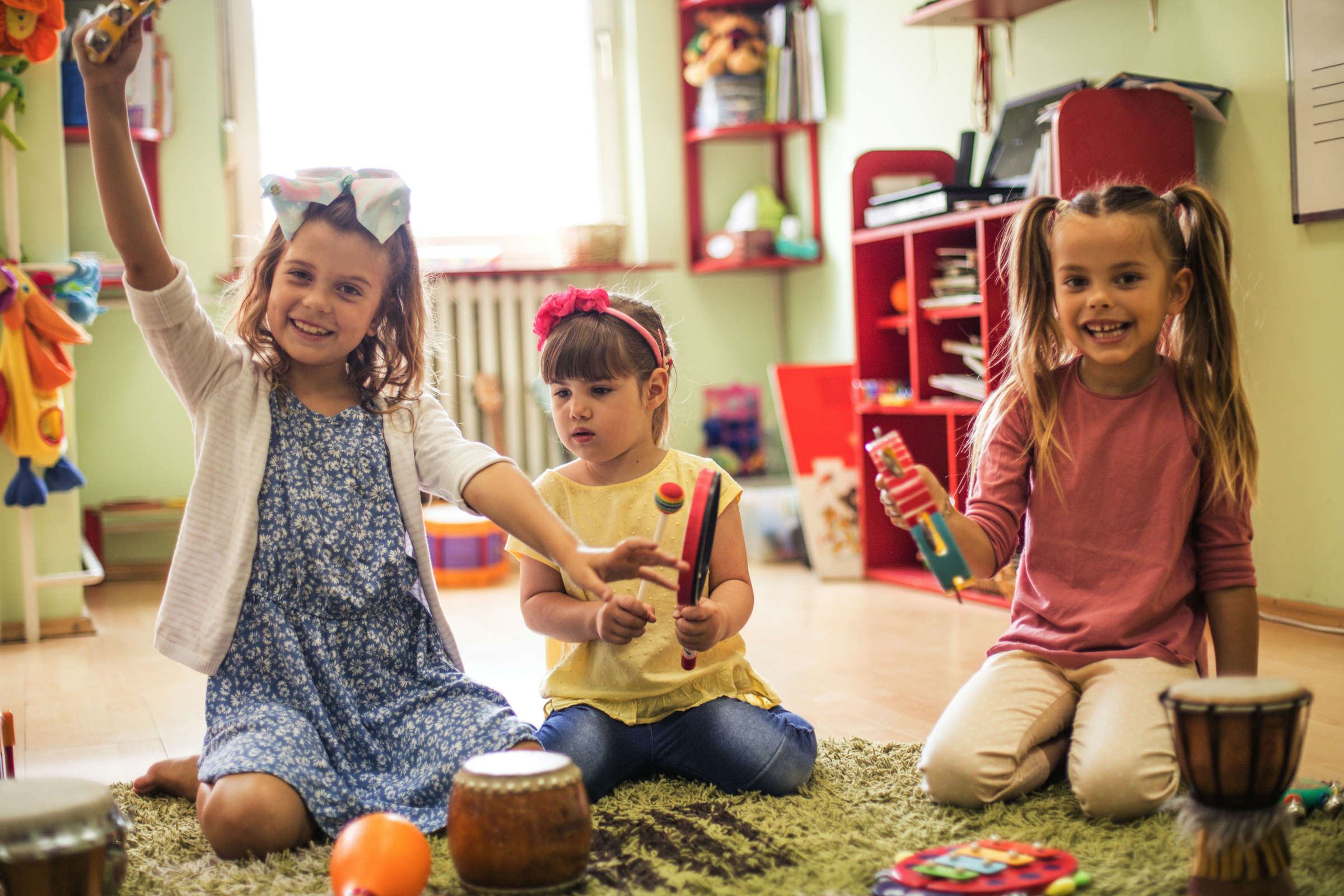 drei kleine Mädchen spielen mit Instrumenten